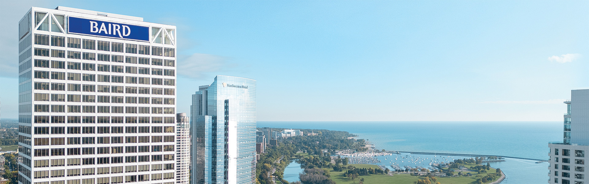 Baird signage atop U.S. Bank Center in the Milwaukee skyline overlooking Lake Michigan