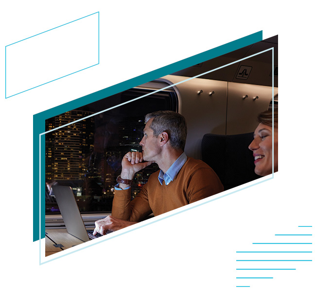 a businessman on a laptop staring out the window of a train